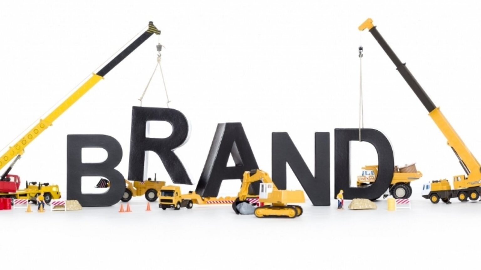 Model construction vehicles building the word brand, illustrating brand development