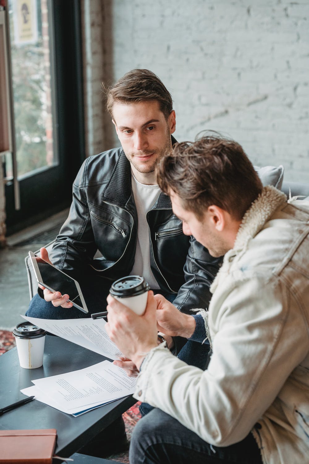 Two people reviewing documents and a tablet during a marketing consultation