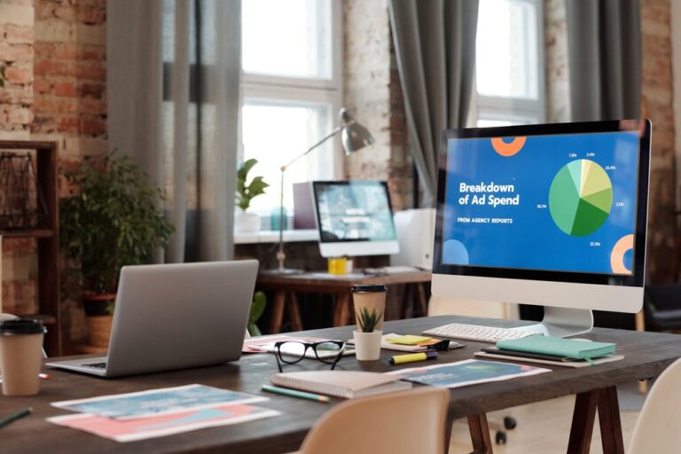 Advertising workspace with campaign spending charts on a desktop monitor