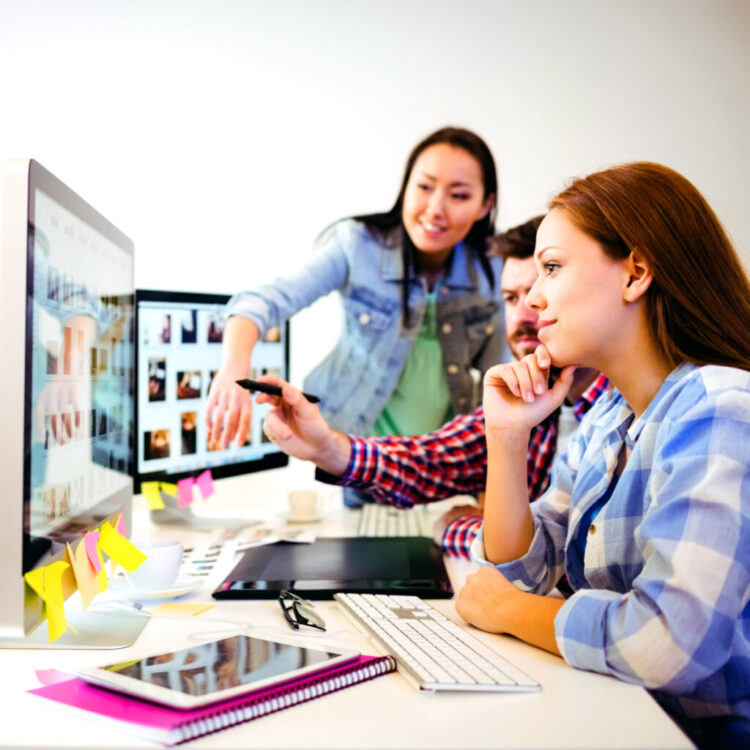 Three colleagues reviewing visual content together for campaign planning
