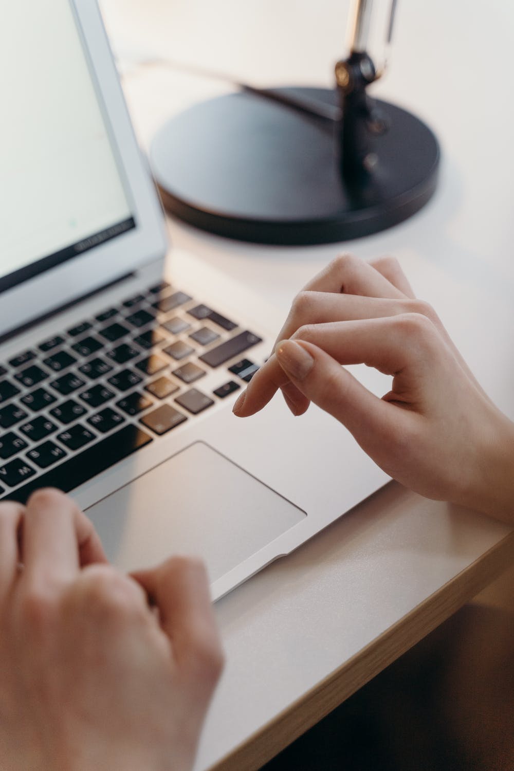 Hands using a laptop trackpad for website research and optimization