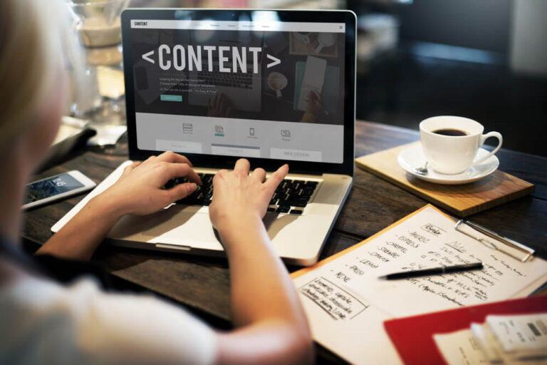 Writer preparing website content on a laptop beside planning notes