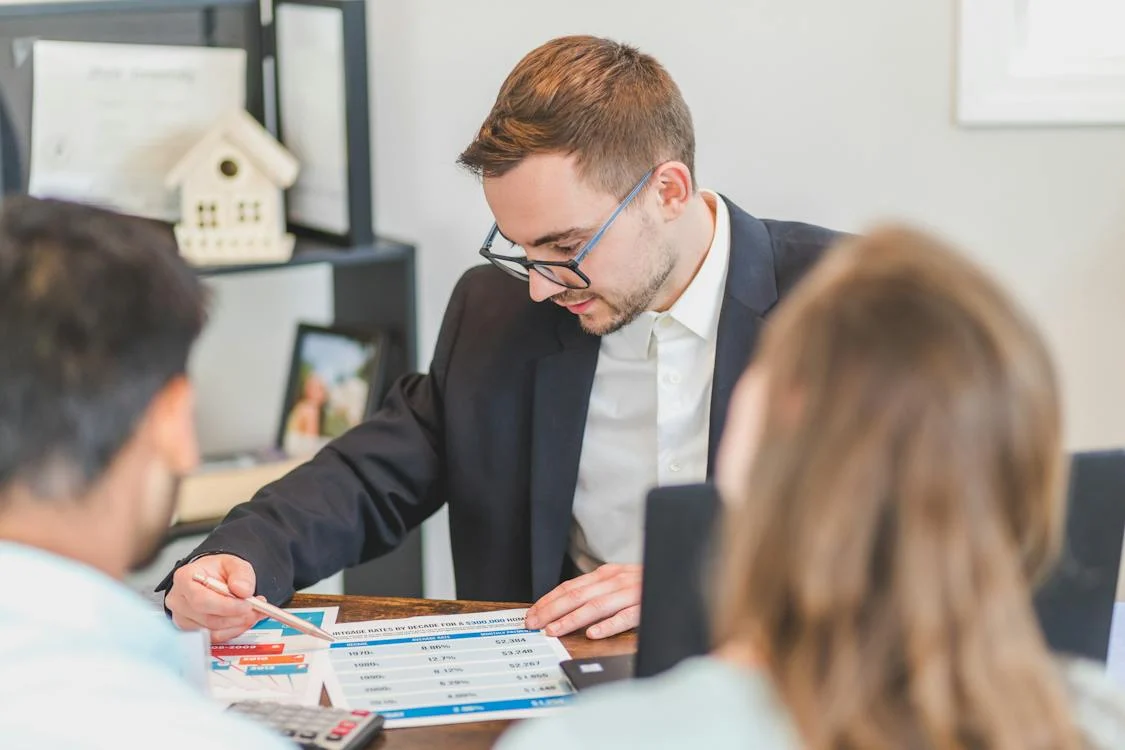 Real estate consultant reviewing property information with two clients
